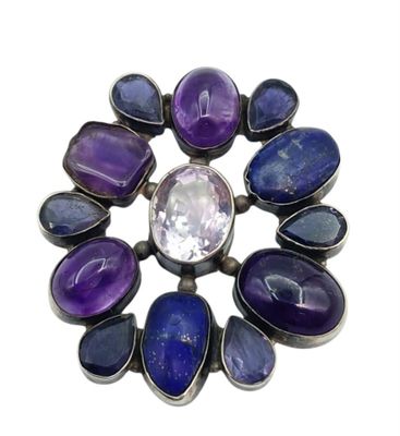 un gros plan sur une broche en pierre violette et bleue