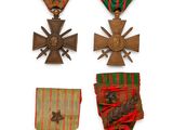 several medals and crosses are displayed on a white surface