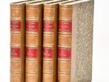 three old books sitting on top of each other on a white surface