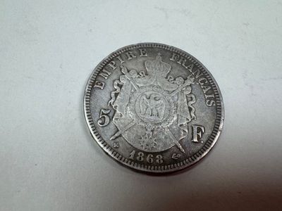 a close up of a silver coin on a white surface