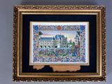 tableau représentant un château, dans un cadre doré, accroché à un mur bleu