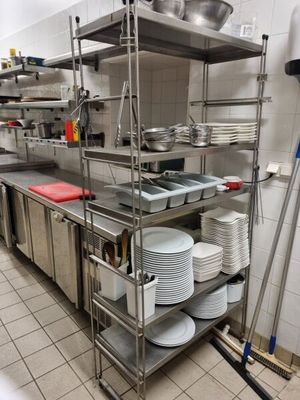 many plates and pans on the shelves in the kitchen