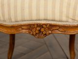 a close up view of a wooden chair with a striped upholstered seat
