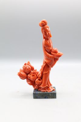 une statue orange représentant une femme tenant un panier de fleurs