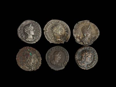 six pièces de monnaie romaines sur fond noir