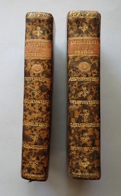 two old books are sitting side by side on a white surface