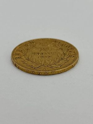 gros plan d'une pièce d'or sur une surface blanche