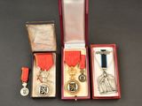 three medals are in a red box on a black surface
