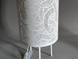 a white lamp that is on a stand with a remote control
