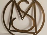 a close up of a metal clock with the letter a in a circle
