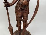 an image of a statue of a man holding a bow and a staff