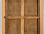 an old wooden cabinet with a glass door on the top of it