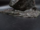 a statue of a bird sitting on top of a rock