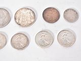 several different coins are arranged in a row on a white surface