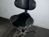 a black office chair sitting on a hard wood floor