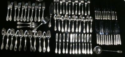 a lot of silver spoons and forks laid out on a table