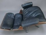 une image représentant un fauteuil et un repose-pieds en cuir noir sur fond blanc