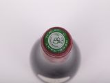 a close up of a bottle of wine on a white surface
