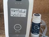 a white and gray device sitting on a counter next to a bottle of water