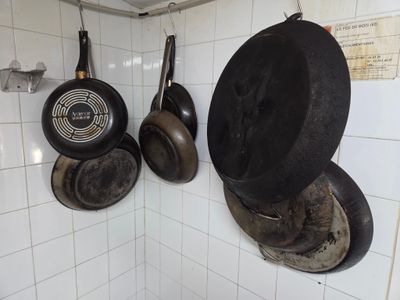 casseroles et poêles accrochées au mur de la cuisine