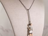 a mannequin with a necklace on it that has a doll on it