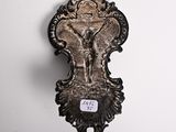 a metal object hanging on the wall with a tag attached to it