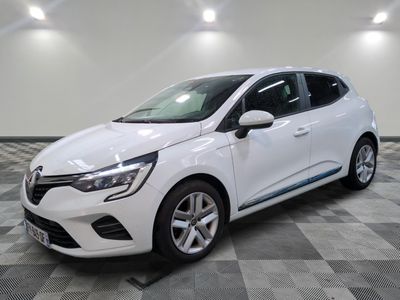 une voiture blanche est garée dans une pièce au sol en damier