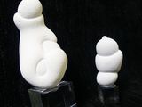 three white sculptures sitting on top of a black surface