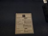a label on the back of a suitcase that is sitting on the floor