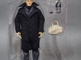 the action figure is in a clear plastic box with a handbag