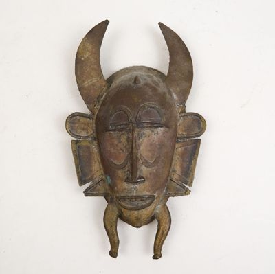 un masque métallique muni de cornes, accroché au mur