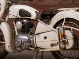 a white motorcycle parked in front of a brick wall