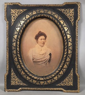 an old picture of a woman in a white dress in a black frame