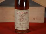 a bottle of wine sitting on a table next to a wooden box