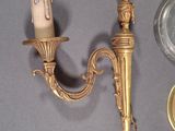 a candle that is sitting on a wall next to a candelier