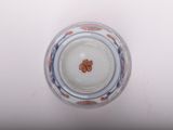 underside view of a blue and white vase with a flower in the center