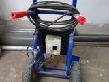 a blue cart with a hose attached to it in a garage