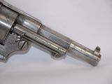 an old silver revolver on a white surface with a white background