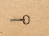 an old key that is laying on a piece of paper