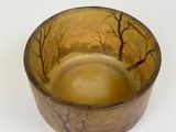 a small bowl with a painting of trees on it