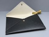 une enveloppe noire et blanche ornée d'un pompon sur le dessus
