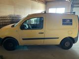a yellow van parked in a garage with a sign on the side of the van