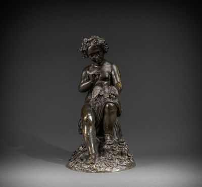une statue en bronze d'une femme assise sur un rocher