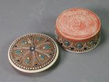 pair of decorative boxes sitting on top of a table next to each other