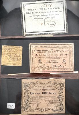 Trois anciens billets de banque français sont exposés dans une vitrine