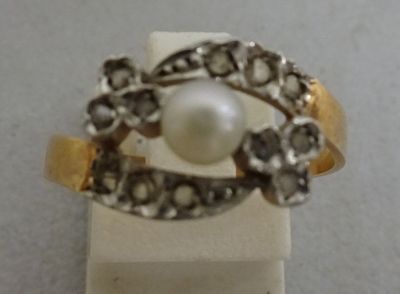 a ring with a pearl in it sitting on a stand