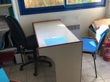 un bureau et une chaise dans une pièce dotée d'une grande fenêtre