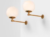 a pair of brass wall lights on a white wall