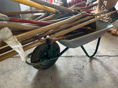a wheelbarrow full of baseball bats in a garage