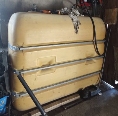un grand réservoir jaune posé sur une palette en bois